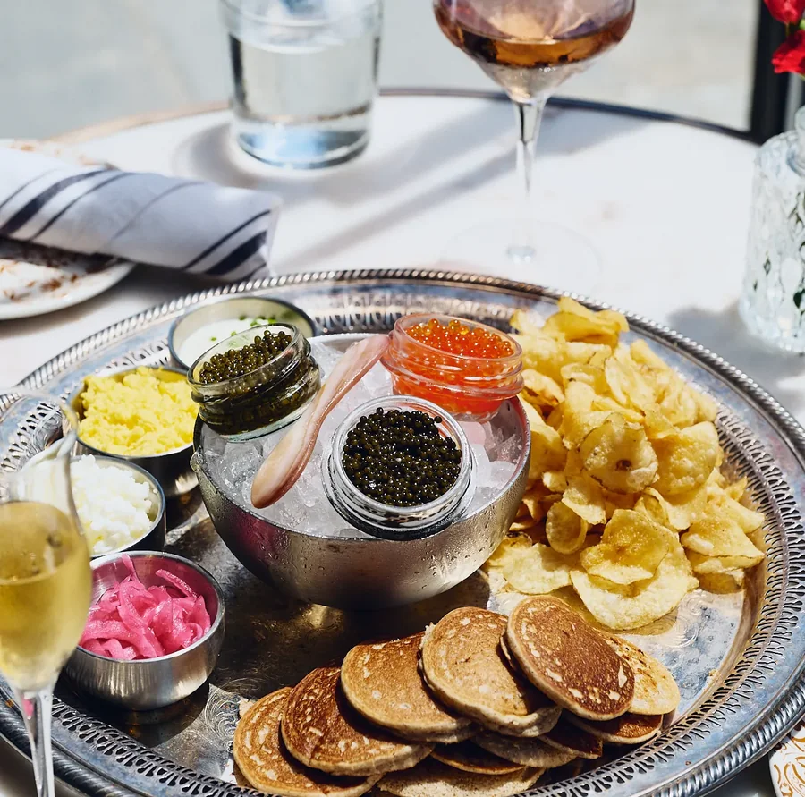 A silver platter of caviar, salmon roe, blinis and potato chips