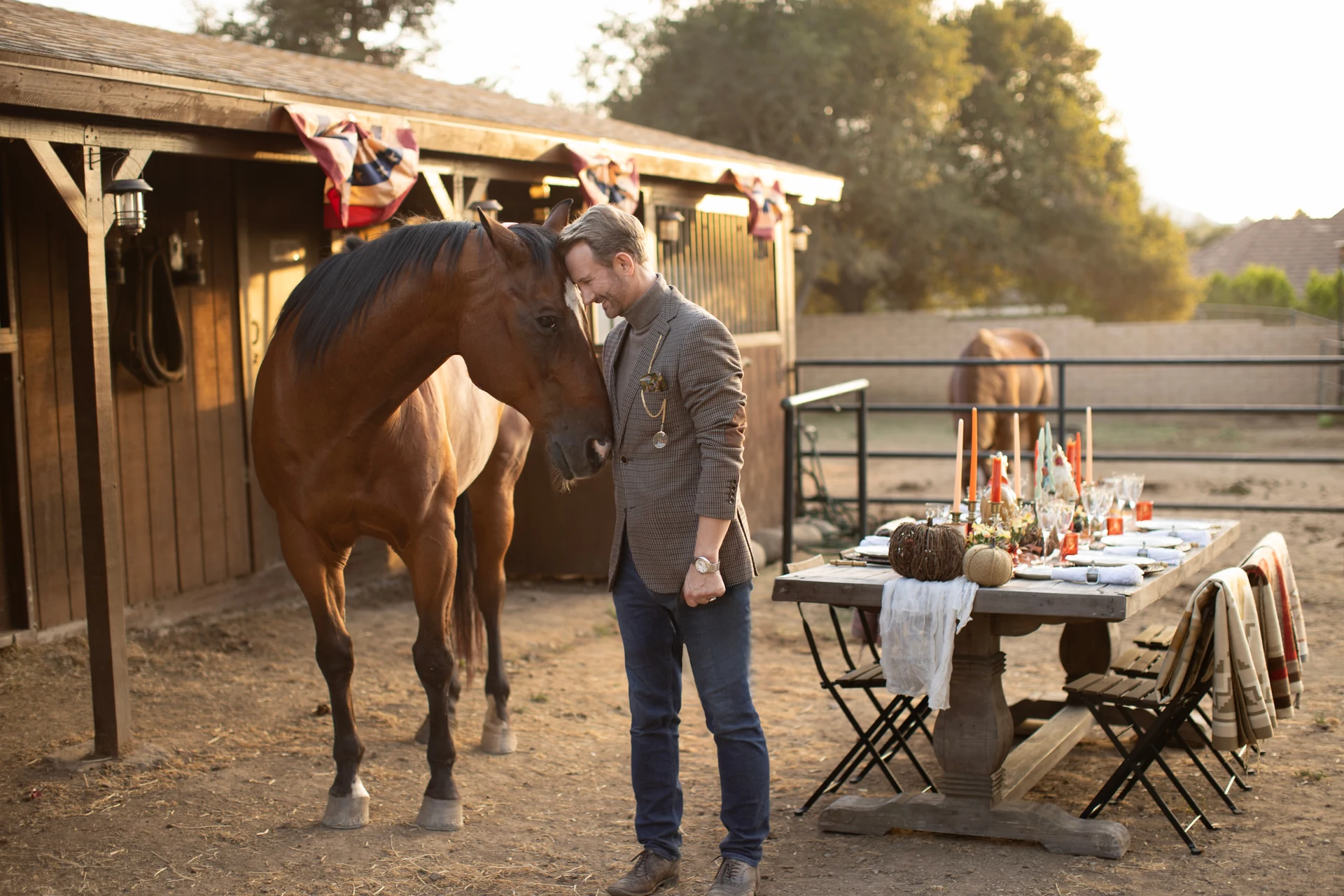 Johan with his horse beside a table set for an autumn gathering